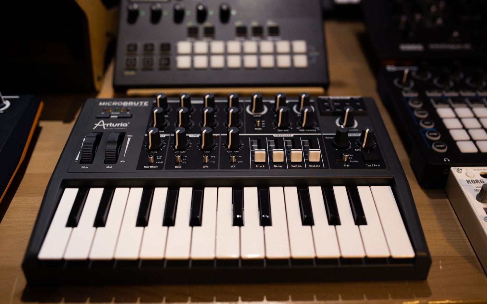 Arturia MicroBrute analog synthesizer with keyboard, knobs and sliders on a shelf