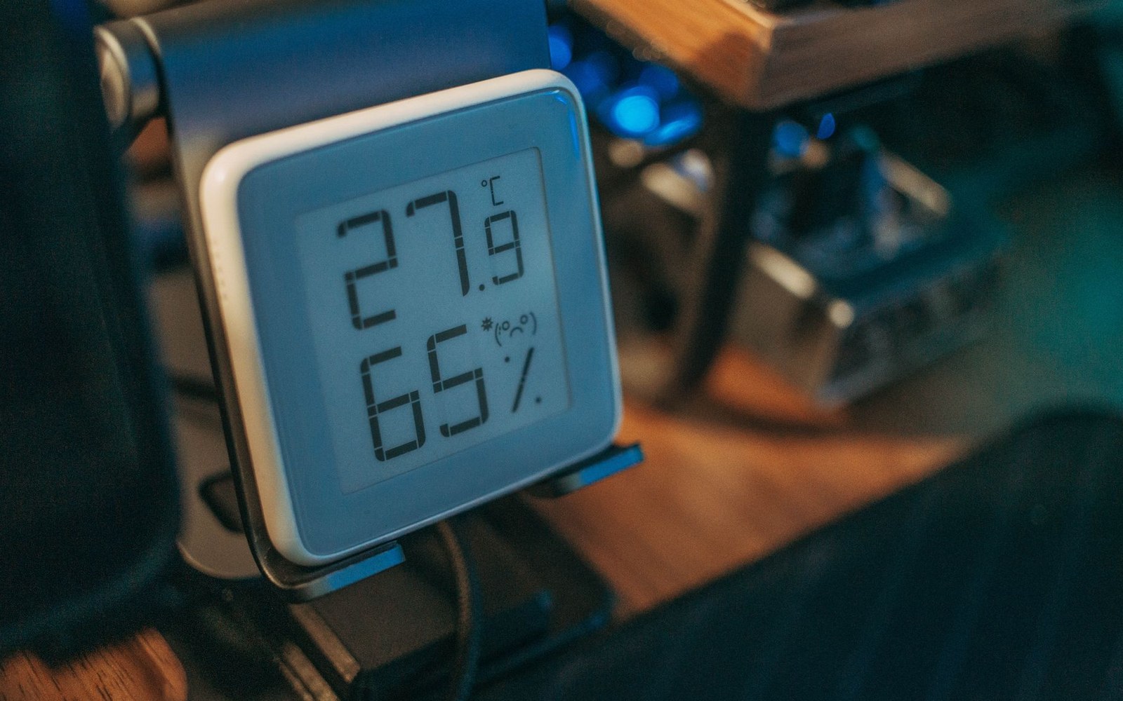 Digital hygrometer displaying 27.9°C temperature and 65% relative humidity with a sad-face icon
