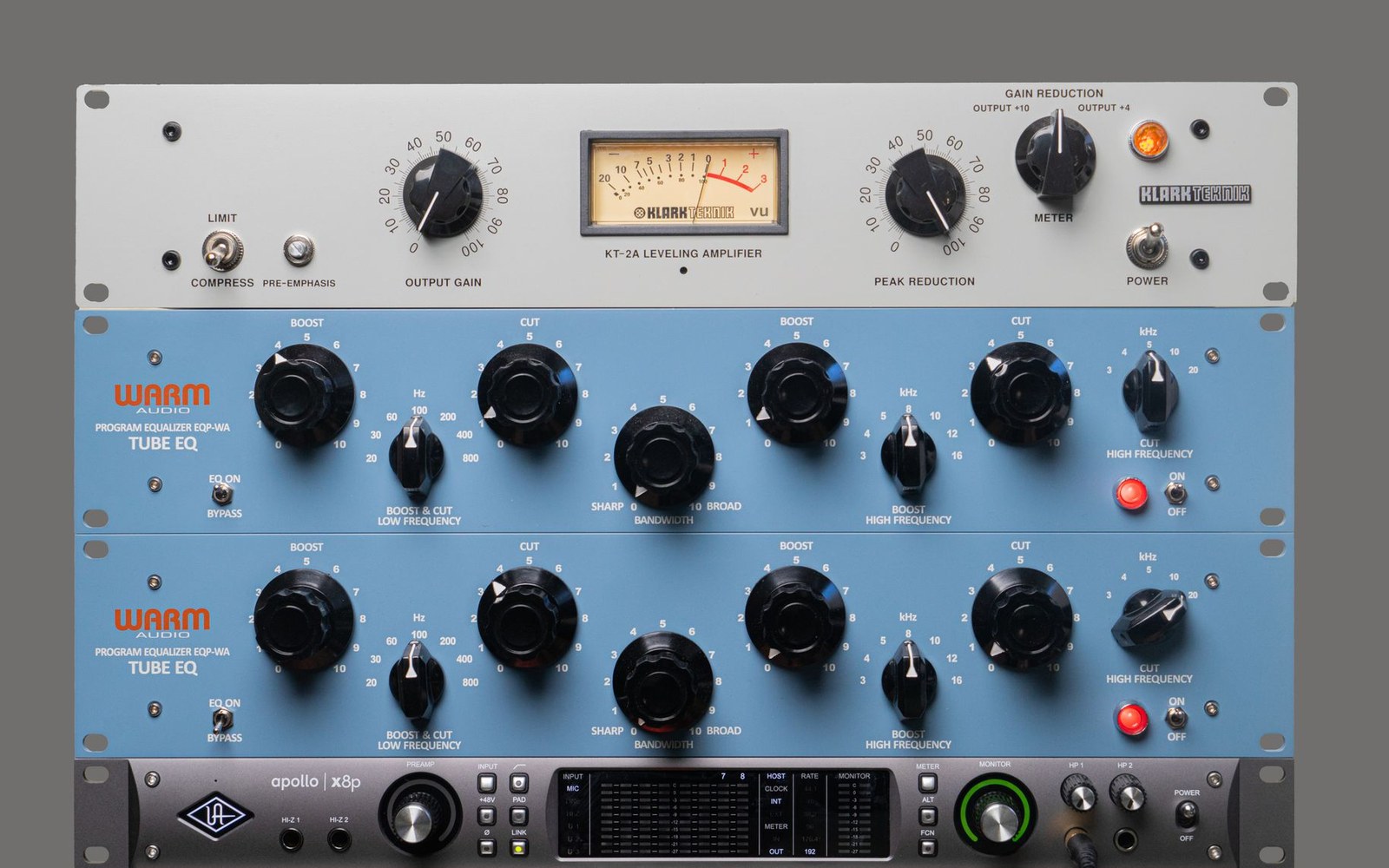 Rack-mounted studio gear including a Klark Teknik leveling amplifier, two Warm Audio tube EQs and an Apollo interface